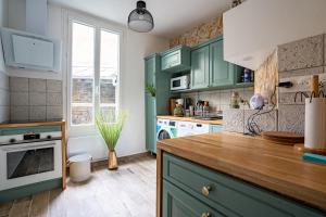 a kitchen with green cabinets and a counter top at Au marche aux puces de saint ouen in Saint-Ouen