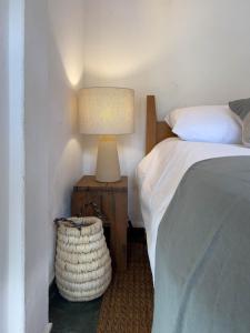 a bedroom with a bed and a table with a lamp at Pousada Vagalume in Tiradentes