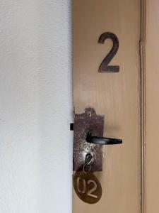 une porte munie d'une serrure et d'un numéro. dans l'établissement Pousada Vagalume, à Tiradentes