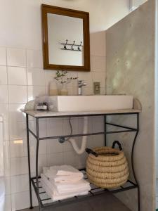 a bathroom with a sink and a mirror and towels at Pousada Vagalume in Tiradentes