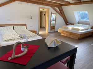 Cette chambre comprend 2 lits et une table avec un tapis rouge. dans l'établissement Gasthaus Kalte Herberge, à Vöhrenbach
