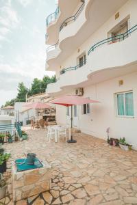 a patio of a building with a table and chairs at Room with amazing sea view in Himare