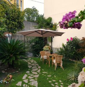 una mesa y sillas bajo una sombrilla en un jardín en Ca' do Dria, en La Spezia