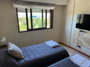 Un dormitorio con una cama azul y una ventana en Departamento excelente vista al mar frente al golf (Alem) en Mar del Plata