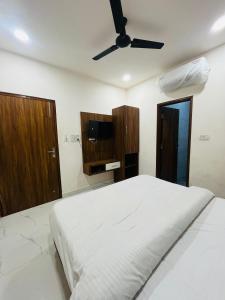 Schlafzimmer mit einem weißen Bett und einem Deckenventilator in der Unterkunft The heaven(close to golden temple) in Amritsar