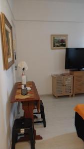 uma sala de estar com uma mesa e uma televisão em Apartamento aconchegante em Petrópolis em Petrópolis