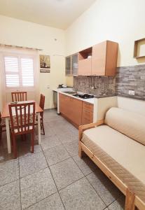 salon z łóżkiem oraz kuchnia ze stołem w obiekcie Sikelia home holiday w mieście Siculiana