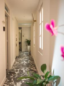 un couloir avec des fleurs roses sur le mur dans l'établissement MUSES LUXURY SUITES, à Corfou