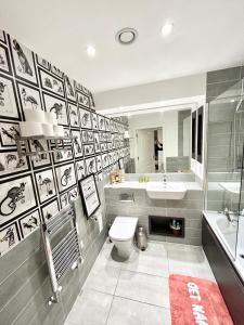 a bathroom with a toilet and a sink and a tub at Modern 2 King BR Apartment with Gym, Rooftop in London