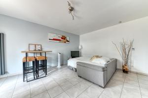 a bedroom with a bed and a couch and a table at La pause côté jardin in Décines-Charpieu