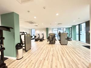 a gym with treadmills and elliptical machines at Modern 2 King BR Apartment with Gym, Rooftop in London
