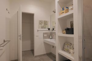 a white bathroom with a sink and a mirror at Mimma's Ground Floor in Rome