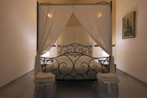 a bedroom with a black bed with curtains and stools at Mimma's Ground Floor in Rome
