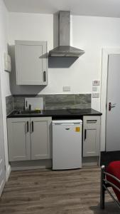 uma cozinha com armários brancos e um balcão preto em Gregory Boulevard - Stay Sleep Rest em Nottingham