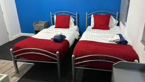 Duas camas num quarto com paredes vermelhas e azuis em Gregory Boulevard - Stay Sleep Rest em Nottingham