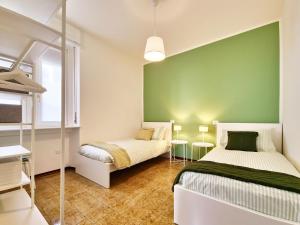 two beds in a room with a green wall at Panoramic lakeview house Bellagio in Civenna
