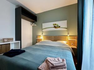Un dormitorio con una cama azul en una habitación. en Repos entre Paris & Disney, en Nogent-sur-Marne