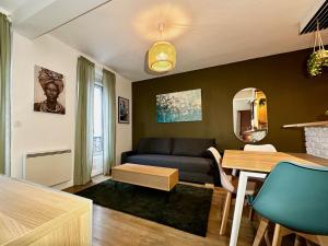 una sala de estar con un sofá y una mesa en Repos entre Paris & Disney, en Nogent-sur-Marne