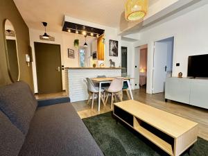 Una sala de estar con un sofá y una mesa con sillas. en Repos entre Paris & Disney, en Nogent-sur-Marne 4 fotos más
