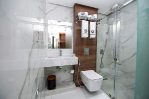 uma casa de banho com um chuveiro, um WC e um lavatório. em MAGNIFIQUE HOTEL em Nador