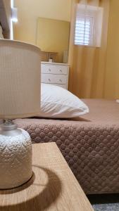 ein Schlafzimmer mit einem Bett und einem Tisch mit einer Lampe in der Unterkunft Sikelia home holiday in Siculiana