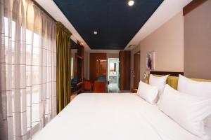 una camera da letto con un grande letto con cuscini bianchi di MAGNIFIQUE HOTEL a Nador