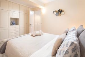 a bedroom with a white bed with two stuffed animals on it at Τ&G Home in Corfu Town