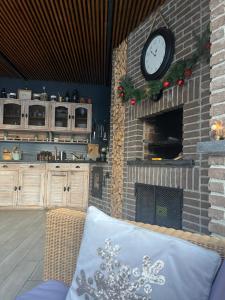 a living room with a clock on a brick fireplace at Roman House Borsa in Borşa