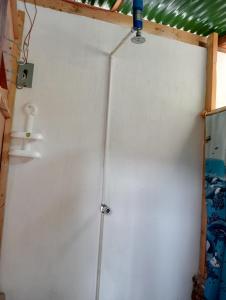 Zimmer mit einer weißen Wand mit einer Pfeife in der Unterkunft Cabaña Tzanjuyu in San Juan La Laguna