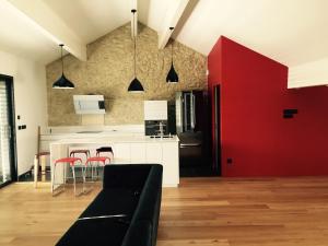 Una sala de estar con un sofá y una cocina roja. en Home Town Center, en Auch