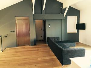 a living room with a black couch and a wooden floor at Home Town Center in Auch