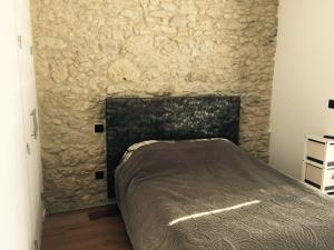 Un dormitorio con una cama y una pared de piedra. en Home Town Center, en Auch