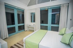 a bedroom with a large bed and large windows at Greencliff Mirissa in Mirissa