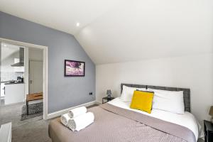 - une chambre avec un grand lit et un oreiller jaune dans l'établissement BridgeCity The Sleek Modern Condo - Maidstone Gem - f9, à Kent