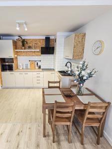 a kitchen with a table and chairs in a room at White Apartment Grzybowska in Warsaw