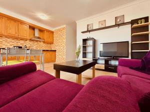 ein Wohnzimmer mit zwei lila Sofas und einer Küche in der Unterkunft Click & Guest - Urban and Quiet House in Vecindario