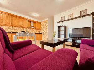 ein Wohnzimmer mit 2 lila Stühlen und einem TV in der Unterkunft Click & Guest - Urban and Quiet House in Vecindario