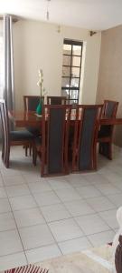 a dining room with a wooden table and chairs at MAMU'S RESIDENCE near JKIA in Nairobi
