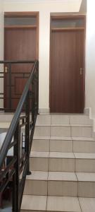 two wooden doors and stairs in a building at MAMU'S RESIDENCE near JKIA in Nairobi