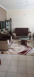 a living room with a couch and a glass table at MAMU'S RESIDENCE near JKIA in Nairobi