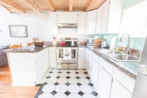a kitchen with white cabinets and a black and white checkered floor at Milwaukie Riverfront Guest House in Milwaukie