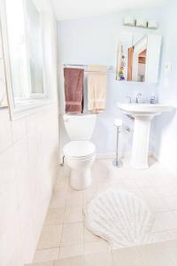 Baño blanco con aseo y lavamanos en Milwaukie Riverfront Guest House, en Milwaukie