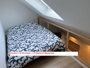 um quarto com uma cama com um edredão branco e azul em Duplex sympa Verviers em Verviers