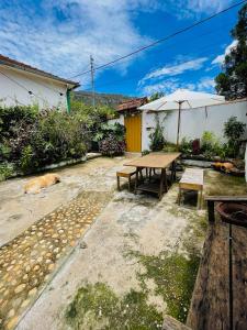 un patio con mesa, bancos y sombrilla en Casinha 87 en Tiradentes