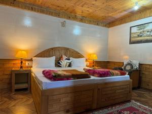 a bedroom with a large bed and two lamps at Nest Villa Homestay in Nagar