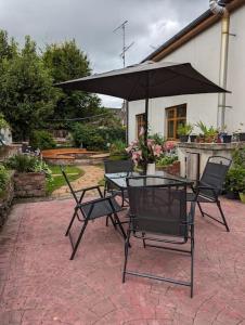 a patio with a table and chairs and an umbrella at TeachinTom in Strabane