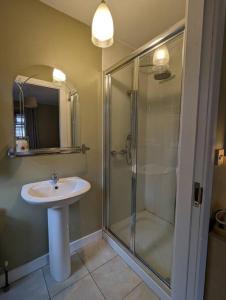 ein Badezimmer mit Glasdusche und Waschbecken in der Unterkunft TeachinTom in Strabane + 10 Fotos