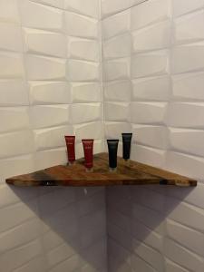 a wooden shelf with four red glasses on it at Villa tangawizi kendwa in Kendwa