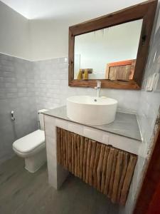 La salle de bains est pourvue d'un lavabo, de toilettes et d'un miroir. dans l'établissement Villa tangawizi kendwa, à Kendwa