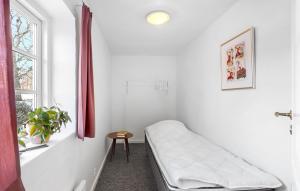 Cette chambre blanche dispose d'un lit et d'une fenêtre. dans l'établissement 2 Bedroom Nice Apartment In Otterup, à Otterup